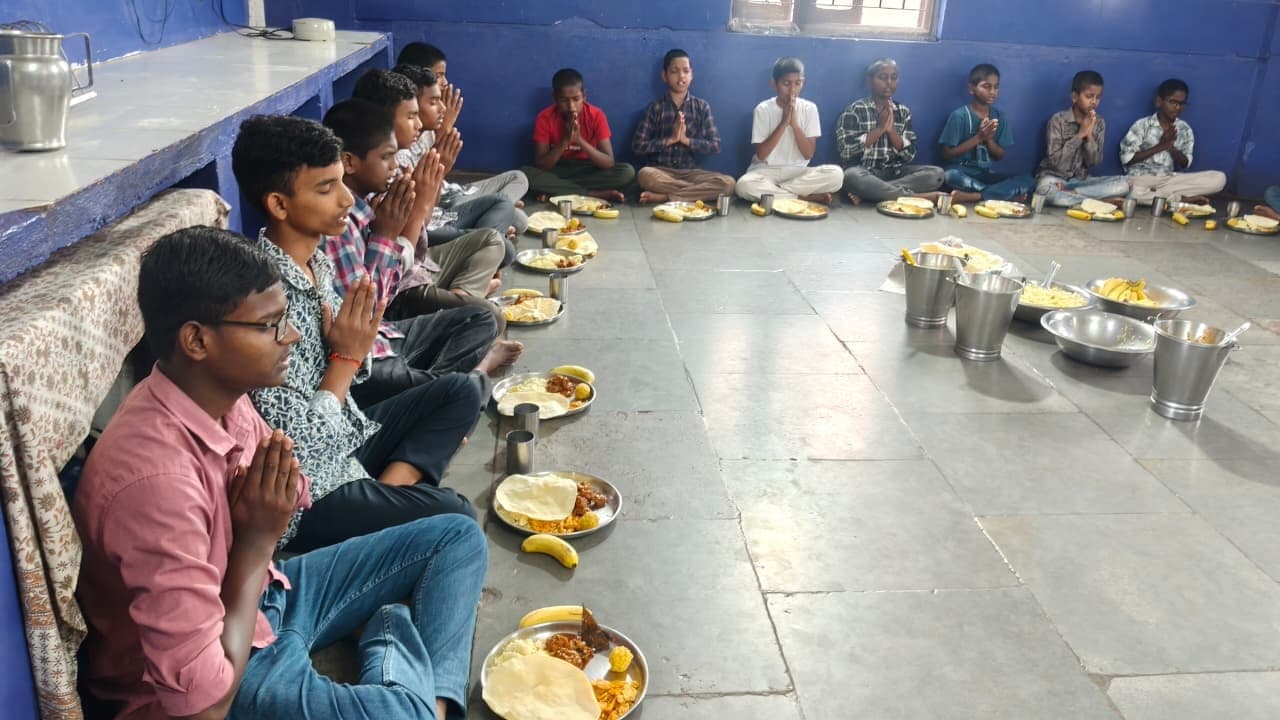 Boys saying grace before a shared meal
